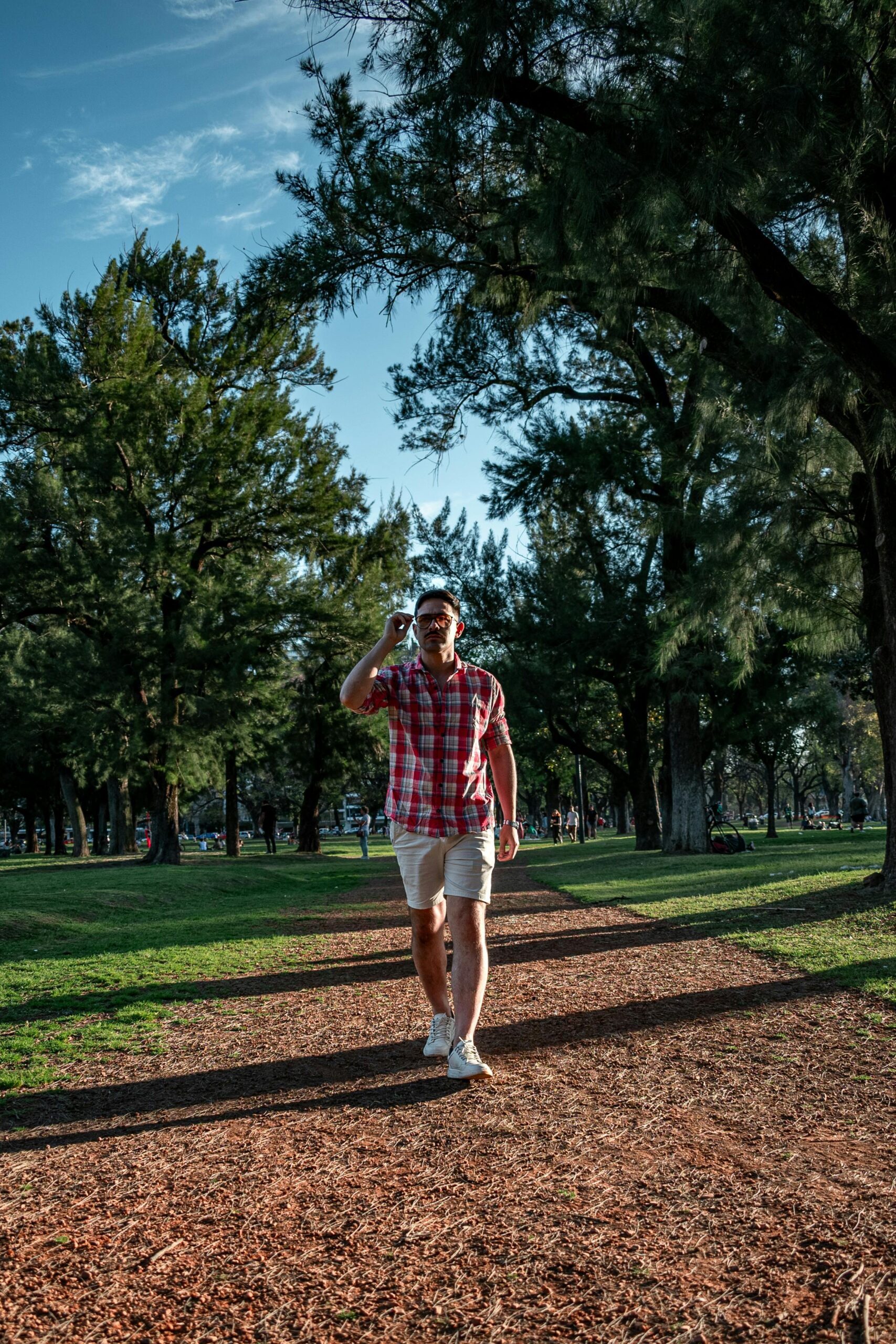 Casual stroll in a Buenos Aires park on a sunny day surrounded by lush greenery.