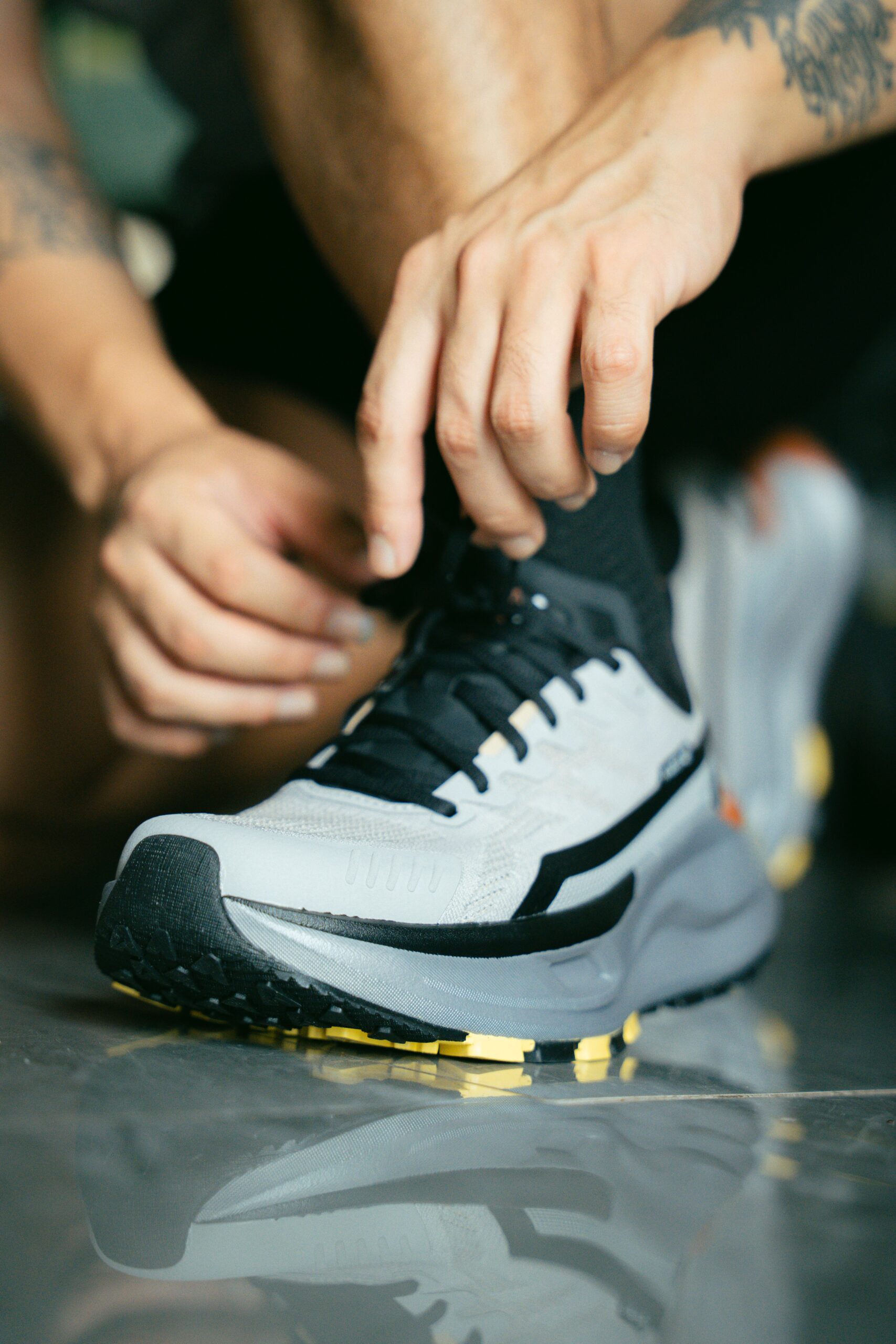 Focused close-up shot of an athlete tying the laces of a running shoe, ready for action.